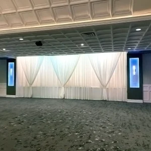 Elegant white draped wall and uplighting backdrop at Macedonian Culture Center banquet hall in Crown Point, Indiana